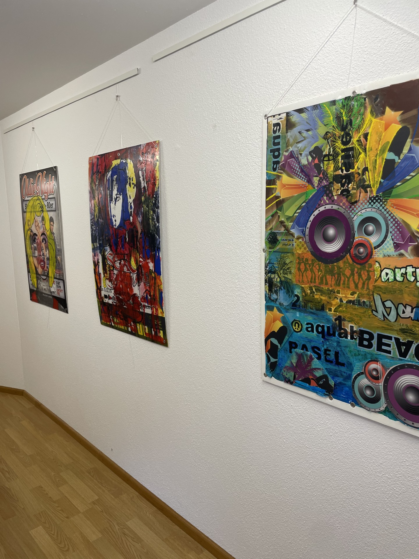 Farbenfrohe Kunstwerke an einer Wand der Galerie Alkoholfrei in Laufenburg