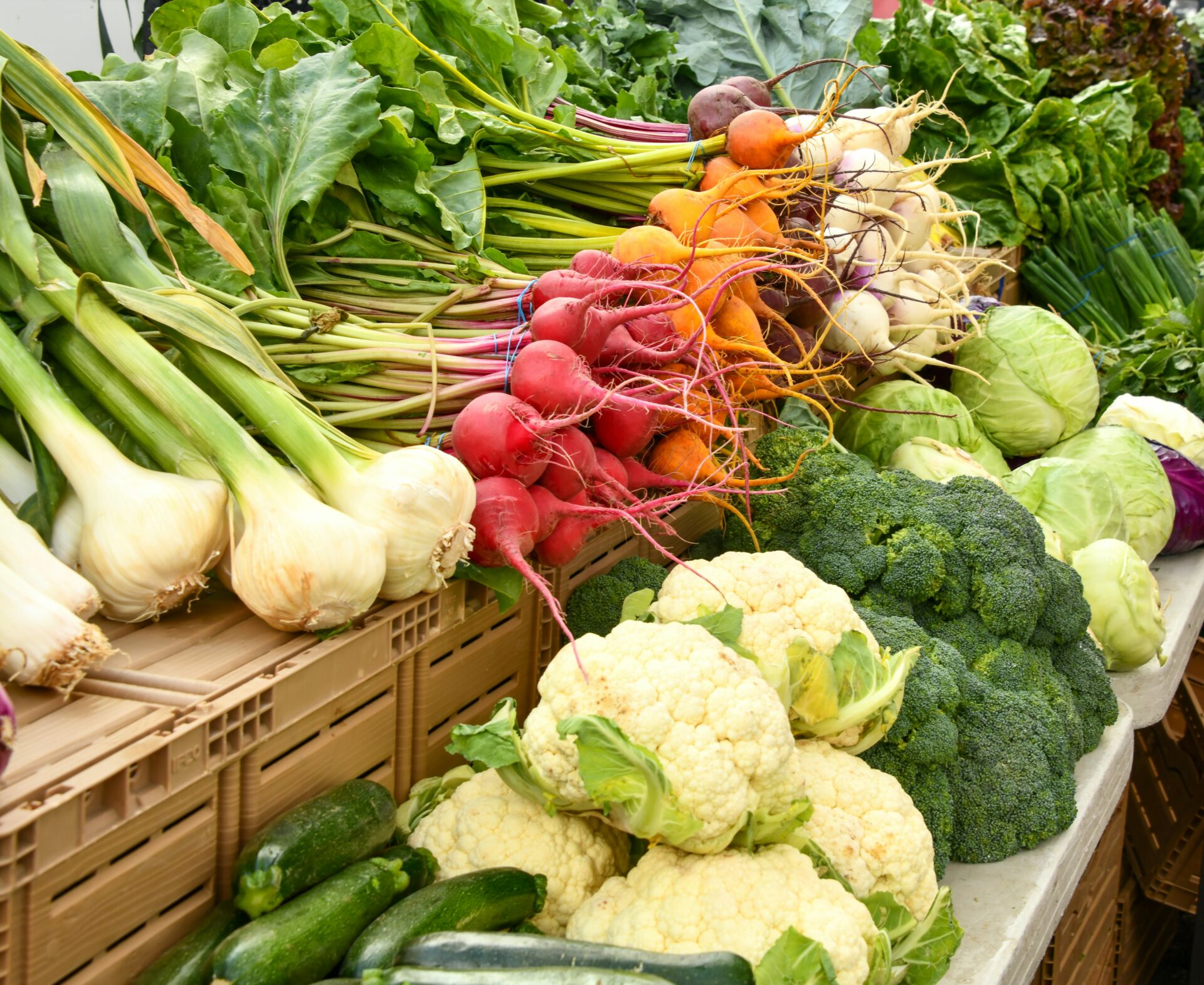 Frisches regionales Gemüse wie Blumenkohl, Brokkoli, Rote Bete, Zucchini und Lauch auf einem Bauernmarkt.