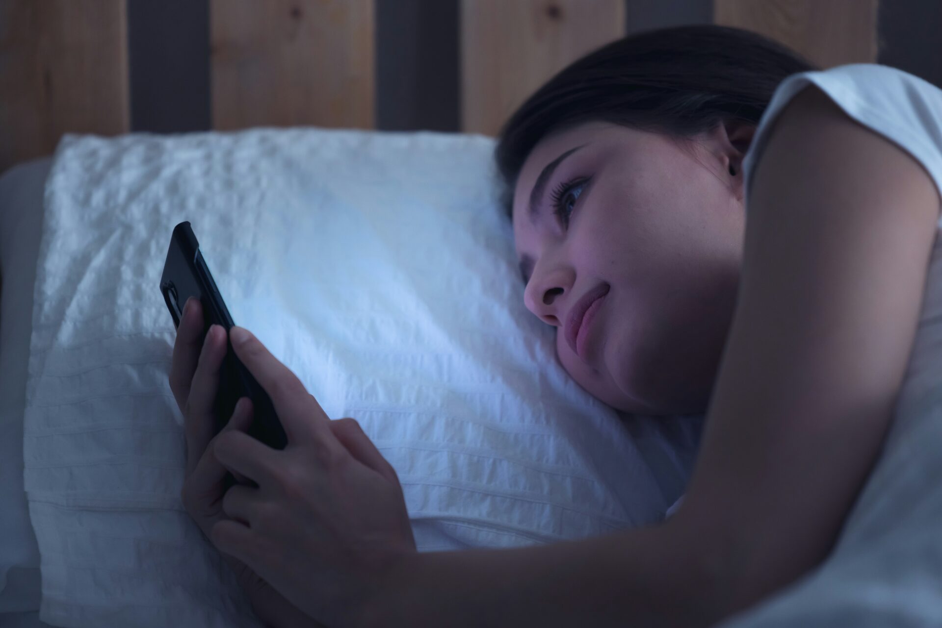 bed rotting smartphone, Frau liegt im Bett und scrollt auf dem Smartphone