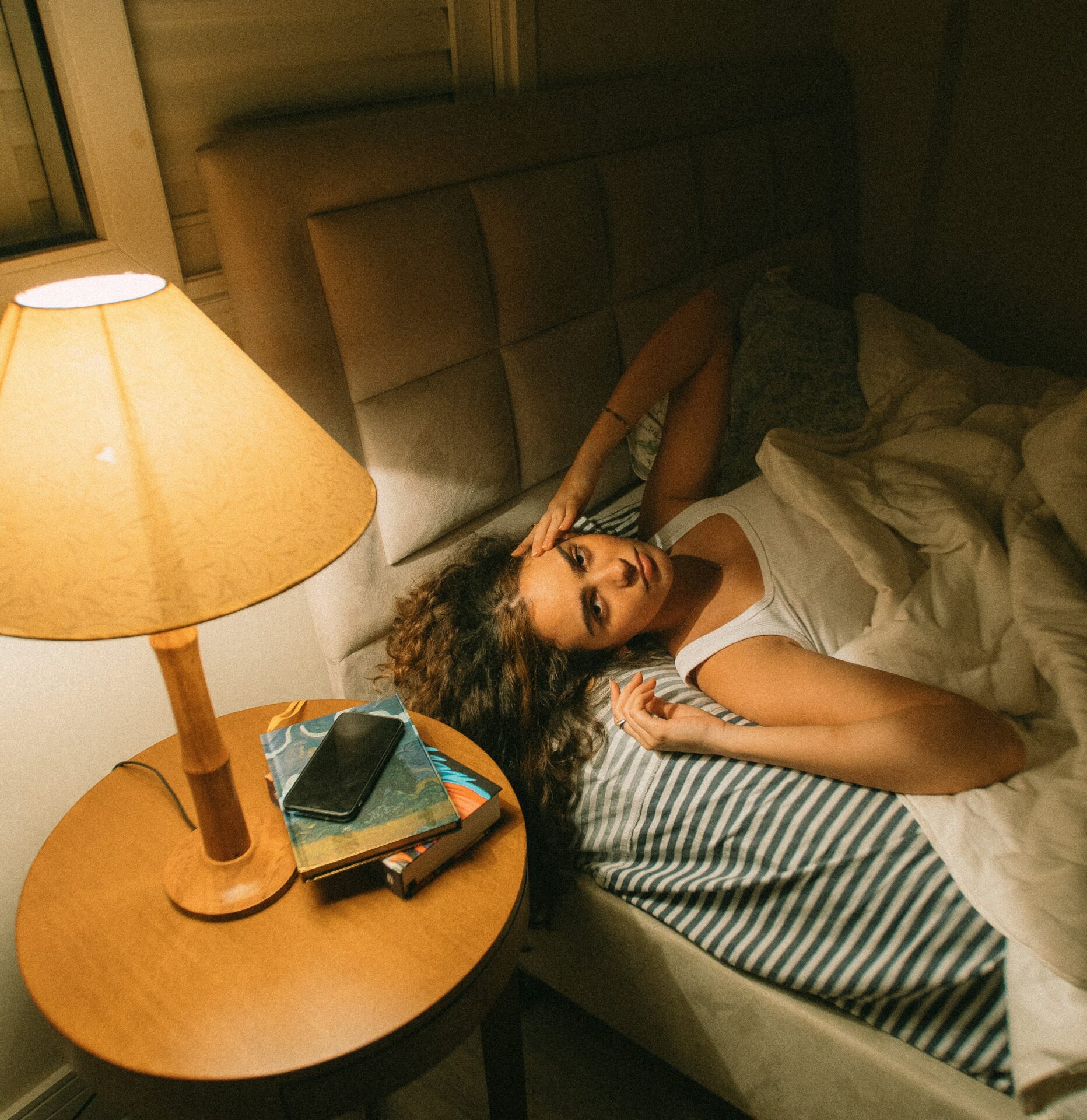 Frau liegt abends wach im Bett nach verschobenem Schlafrhythmus