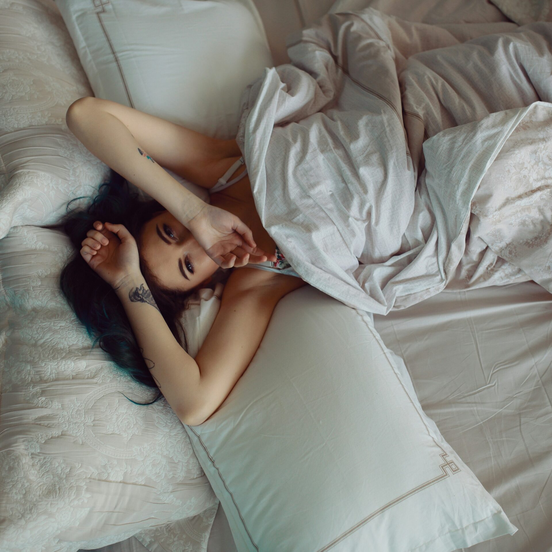 Müde Frau liegt morgens wach im Bett
