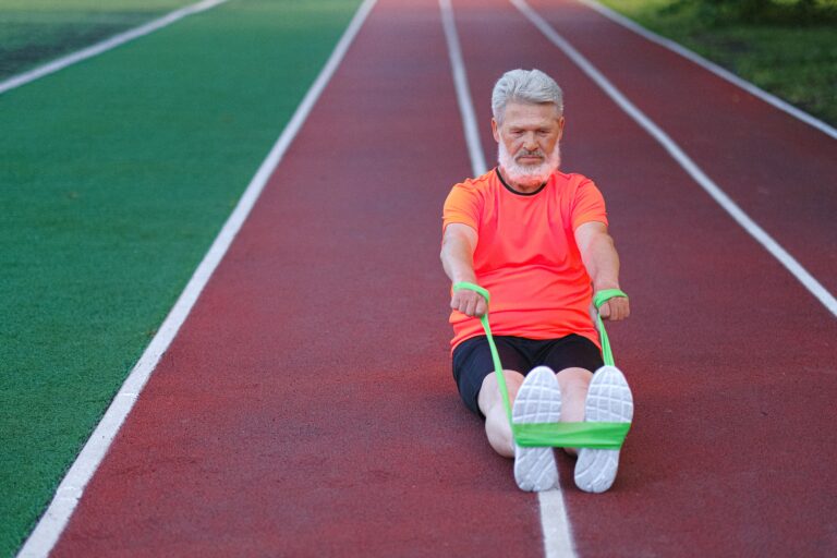 Älterer Mann trainiert mit einem Fitnessband zur Erhaltung seiner Muskelkraft