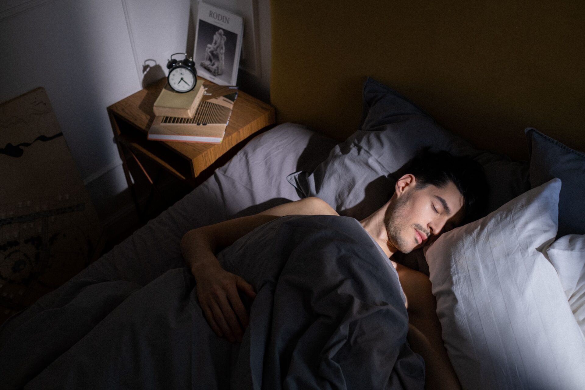 Schlafender Mann in einem nachts schwach beleuchteten Schlafzimmer